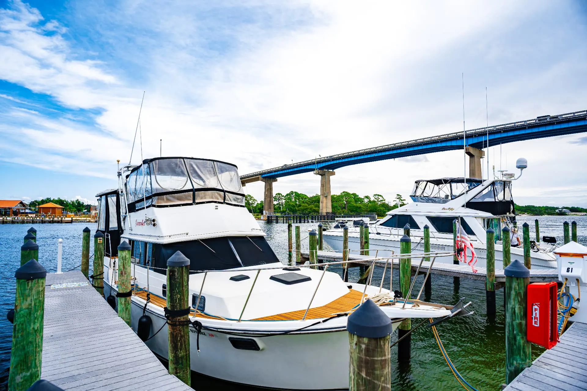 Motor yachts in marina slips with the blue bridge in the distance
