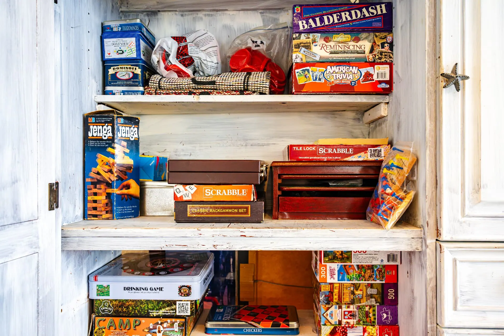 Clubhouse game cabinet stocked with board games and puzzles