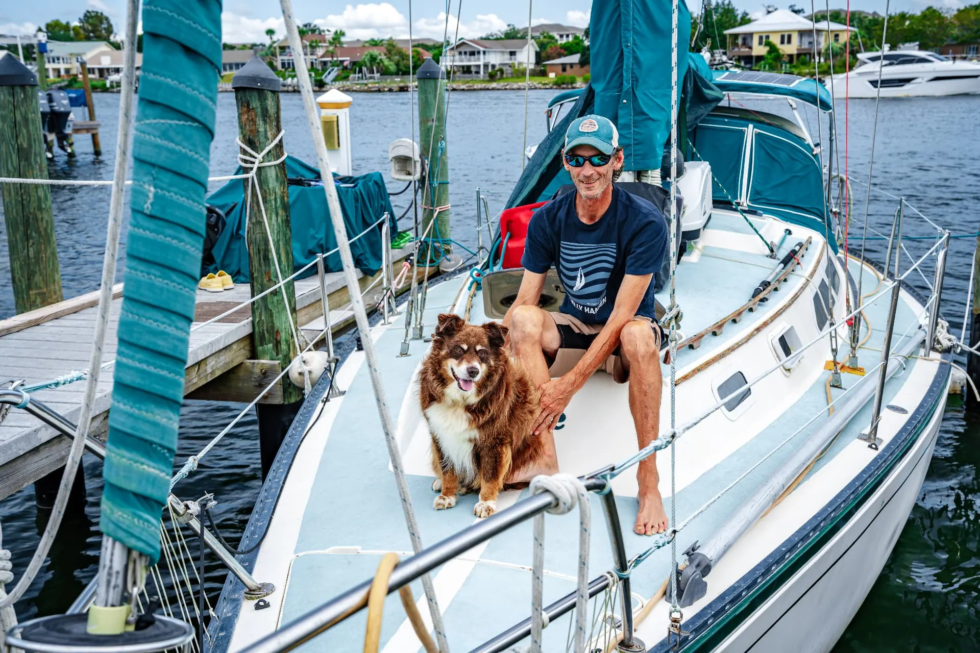 Guest and his dog relaxing on their sailboat at the dock