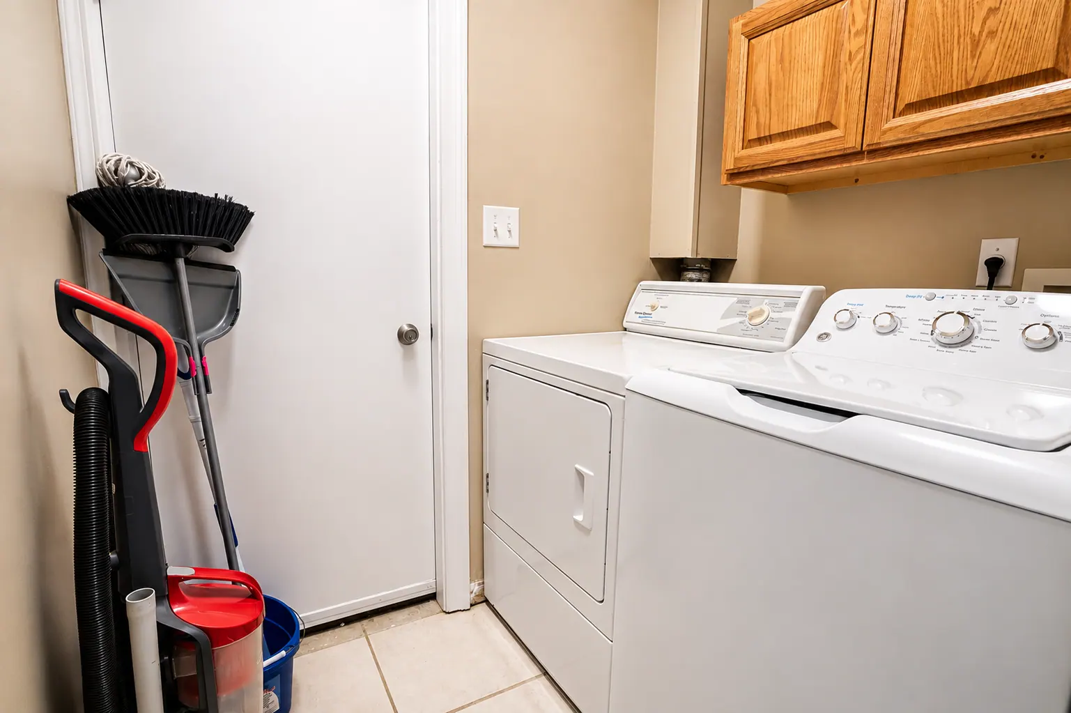 Clean in-unit laundry room with full-size washer and dryer in a furnished condo