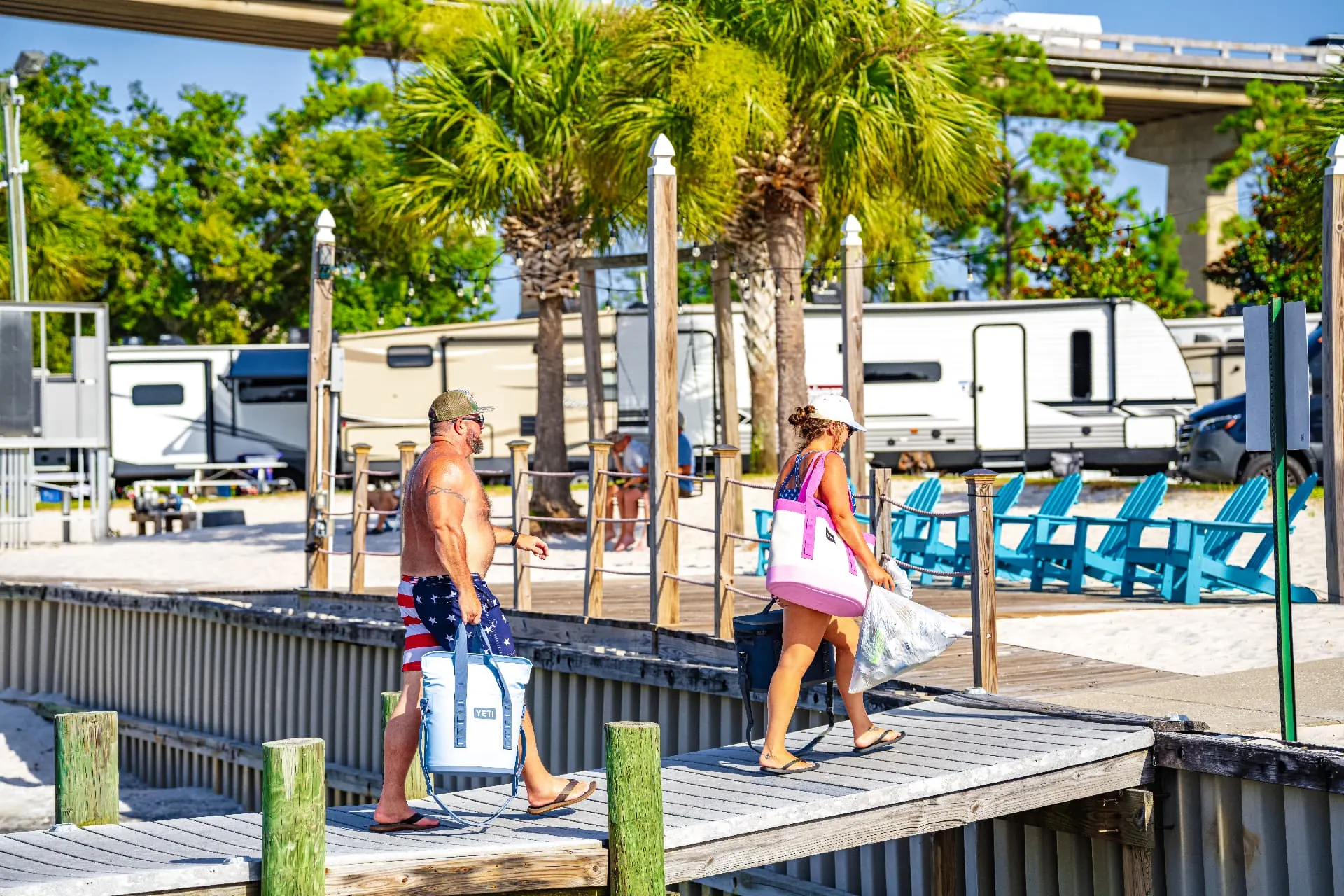 Guests carrying coolers down the dock past the RV sites