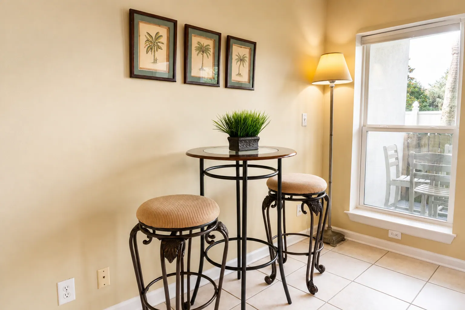 Bistro table with two stools in a sunlit condo nook