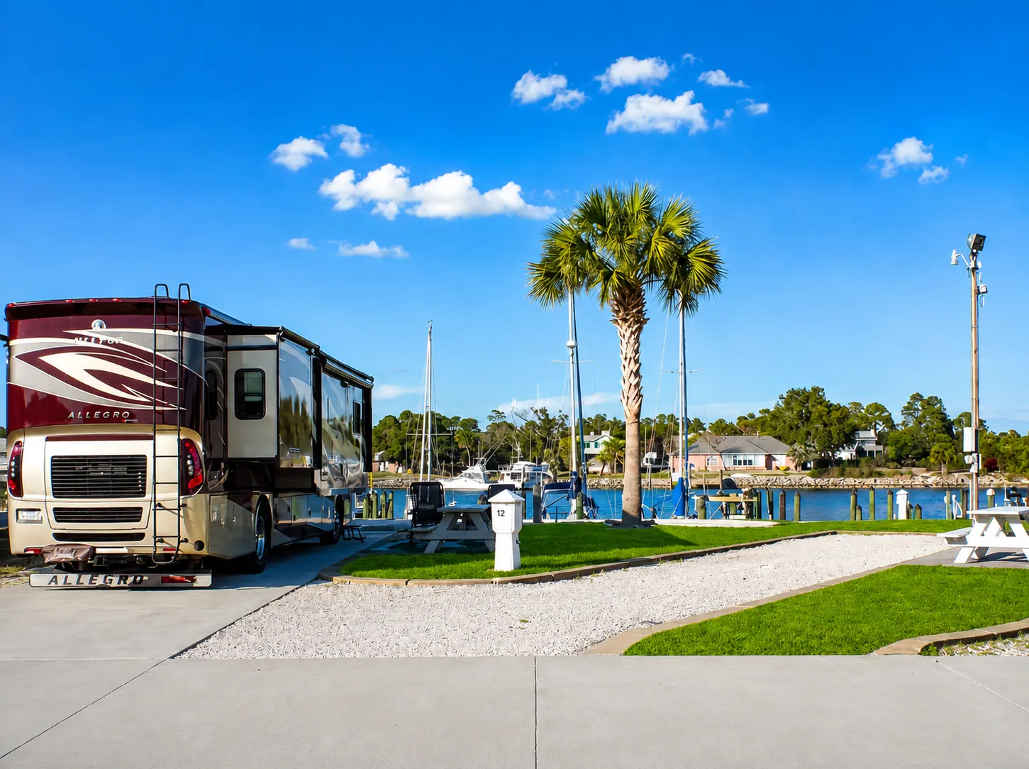 Fifth-wheel RV parked on a full-hookup site with picnic table at Perdido Key RV Resort