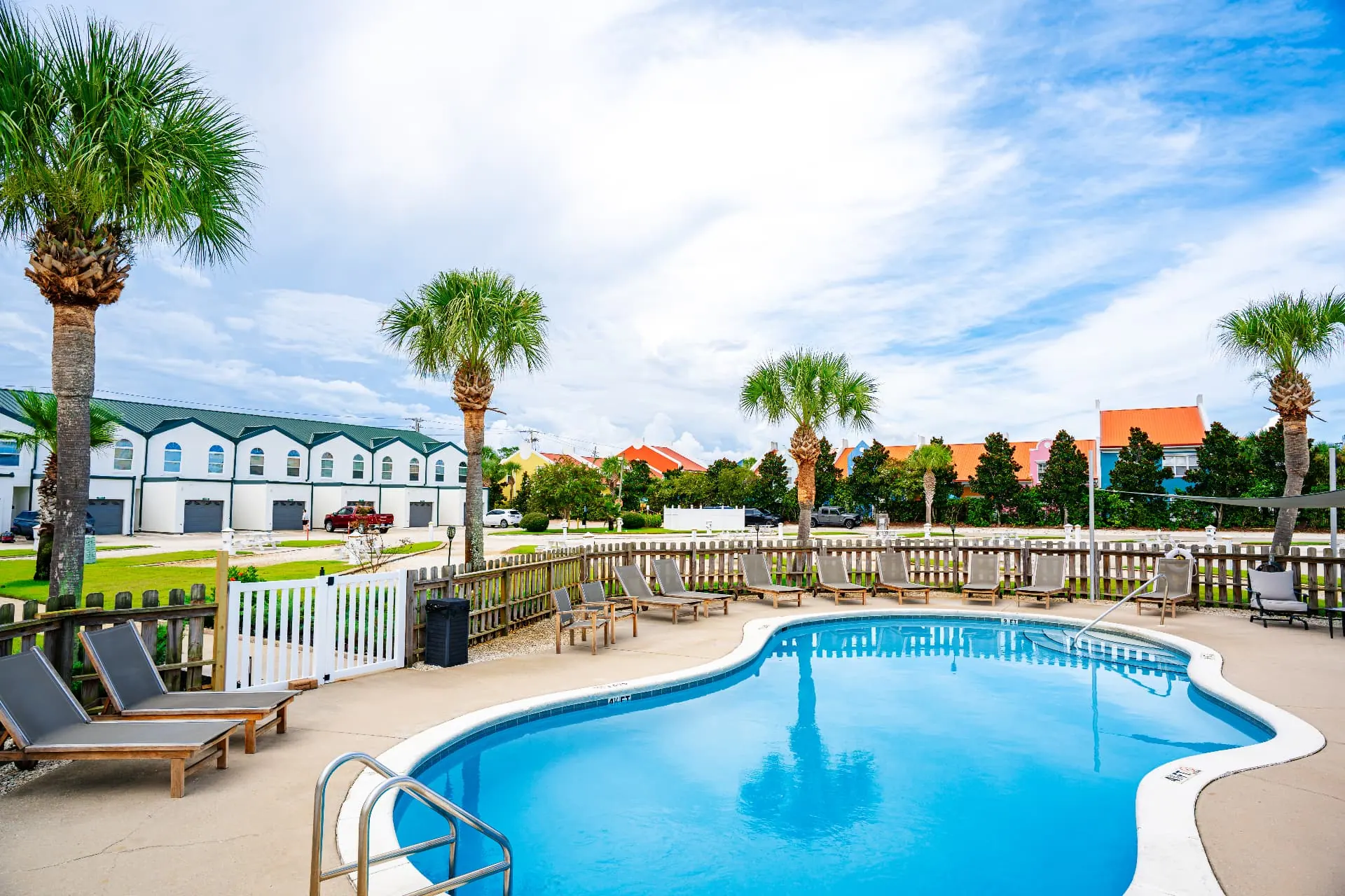 Heated and cooled resort pool surrounded by palm trees
