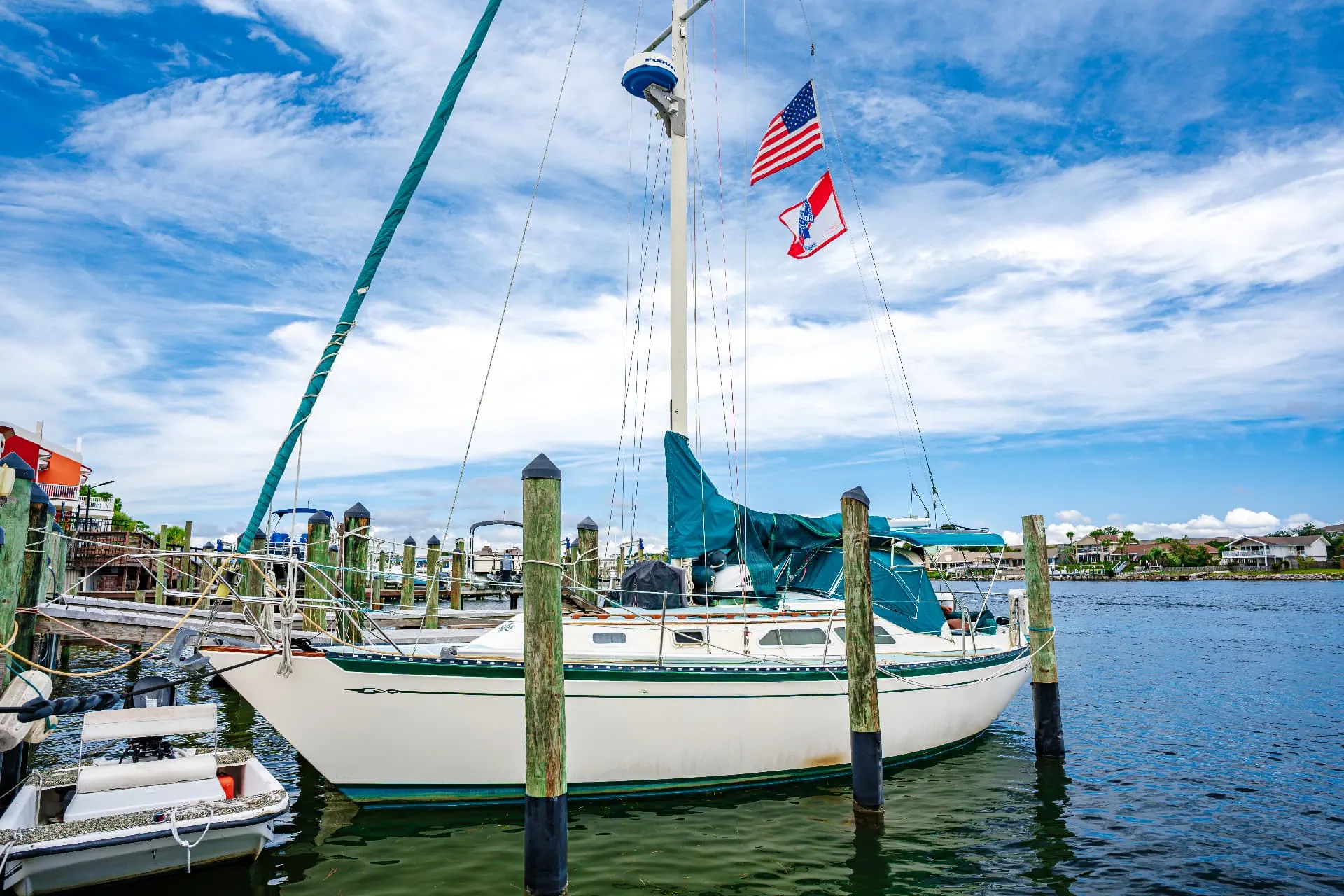 Sailboat flying American and yacht club flags at the dock