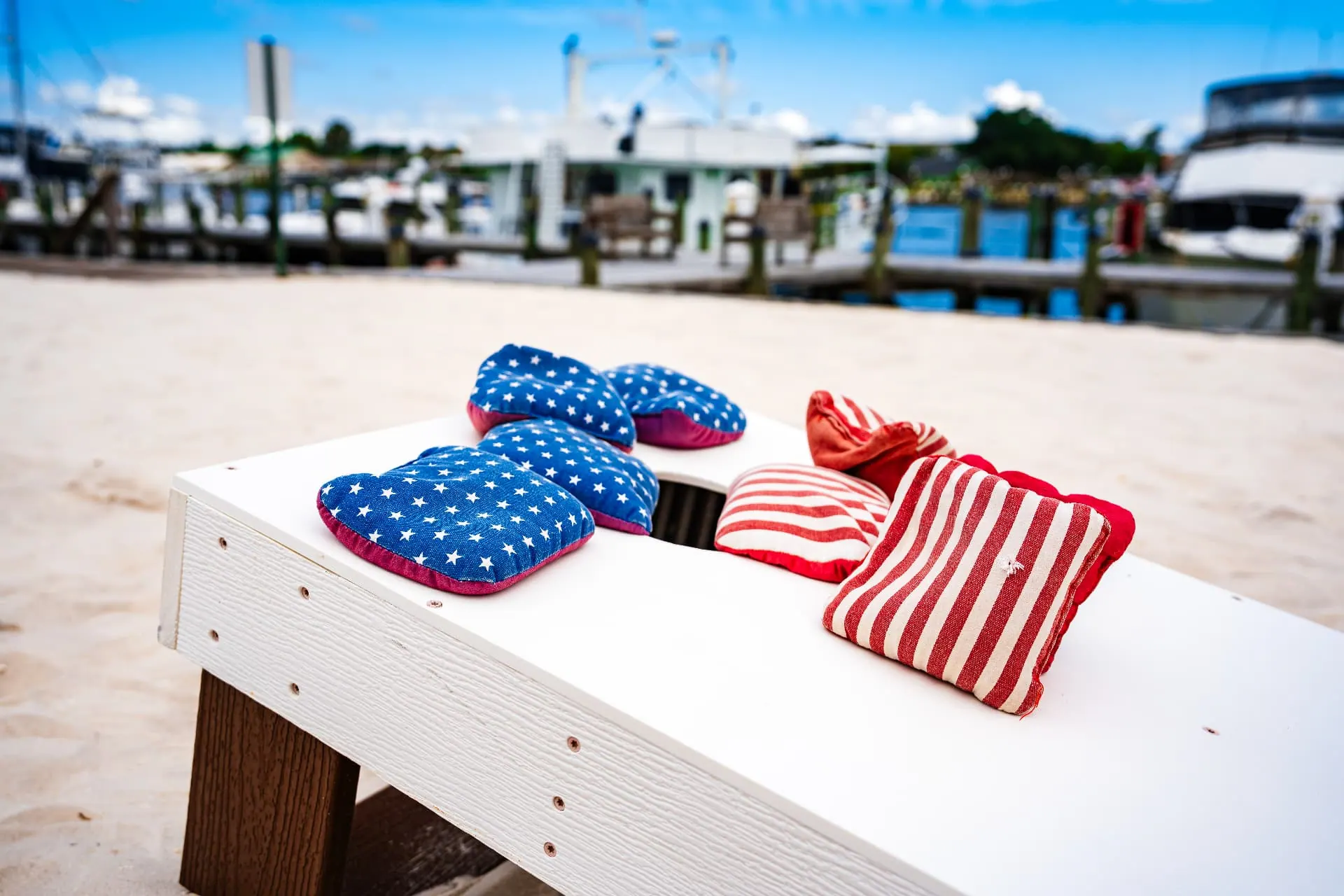 Stars and stripes cornhole bags on a board by the marina