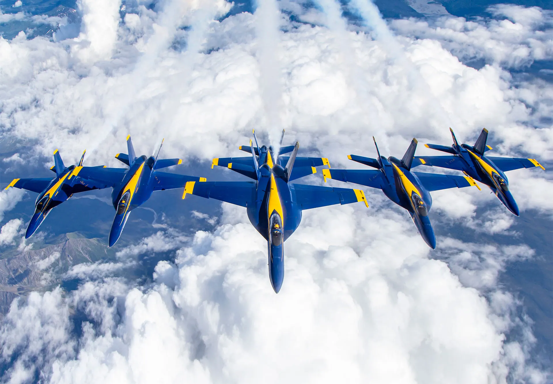 U.S. Navy Blue Angels jets flying in formation over the clouds